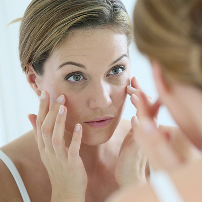 Middle-aged woman applying anti-aging cream